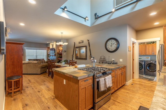 935 Pack Rat Ln, Whitefish, MT 59937 - kitchen with appliances with stainless steel finishes, washer and dryer, light wood-type flooring, a chandelier, and recessed lighting