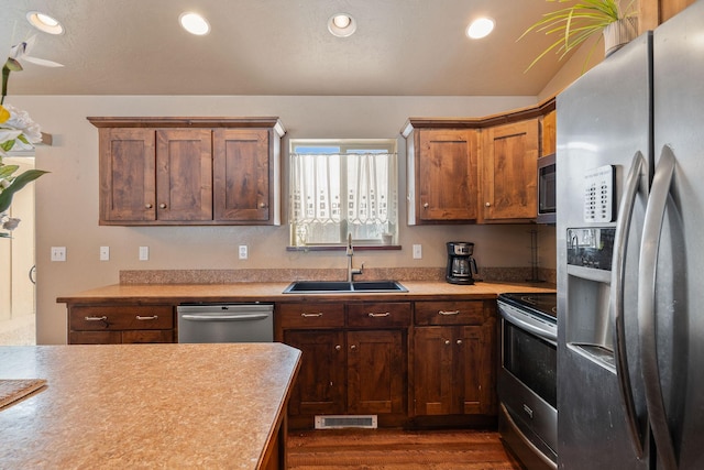 kitchen featuring recessed lighting, stainless steel appliances, a sink, and light countertops