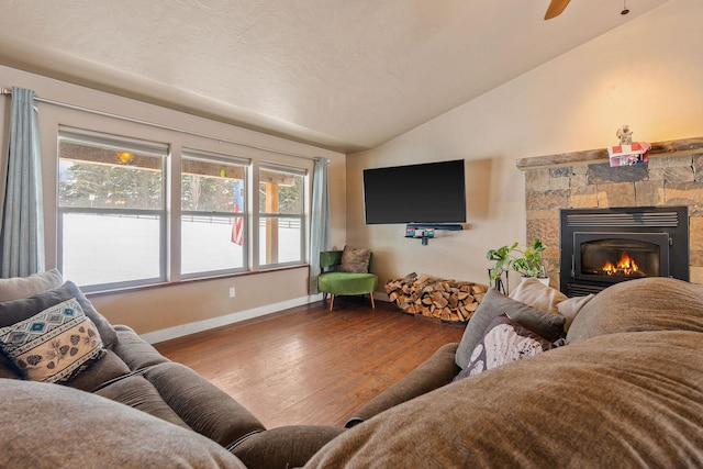 living room with vaulted ceiling, a fireplace, wood finished floors, and baseboards