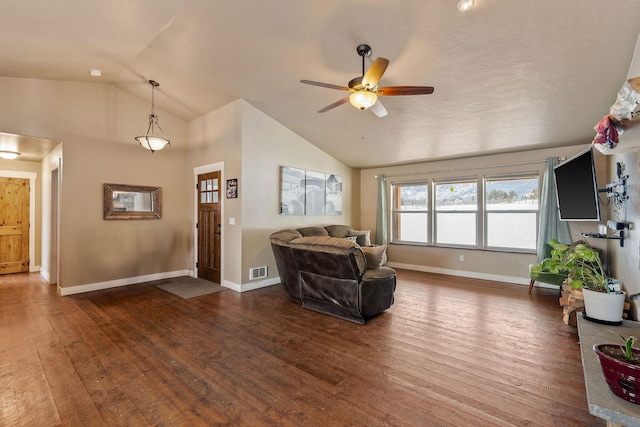 living room featuring dark wood-style flooring, visible vents, vaulted ceiling, ceiling fan, and baseboards