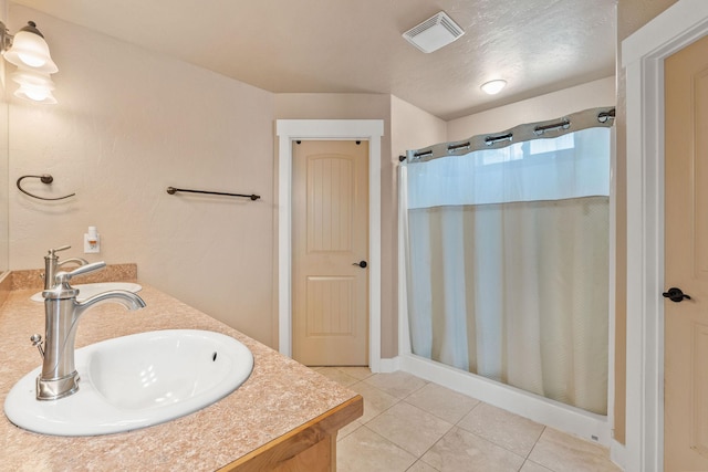 bathroom with a shower with curtain, visible vents, a sink, and tile patterned floors