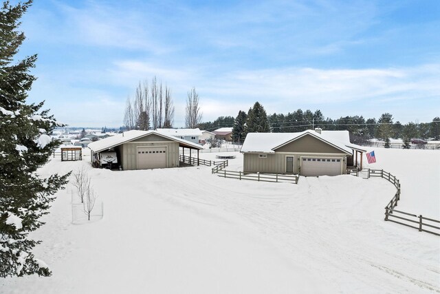 ranch-style home featuring a garage, an outdoor structure, and fence