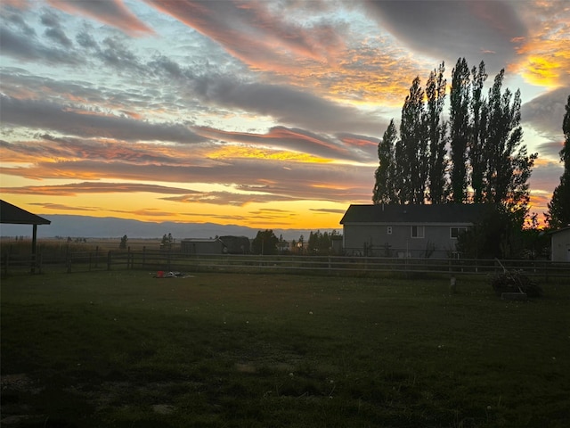 yard at dusk with fence and a rural view