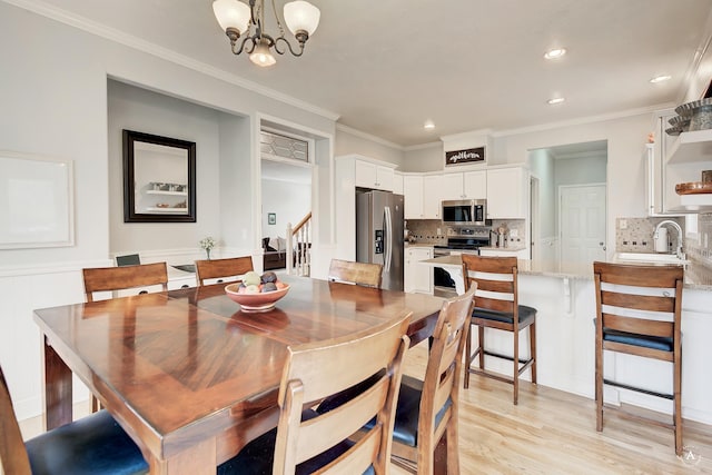 dining room featuring stairs, crown molding, light wood finished floors, and an inviting chandelier