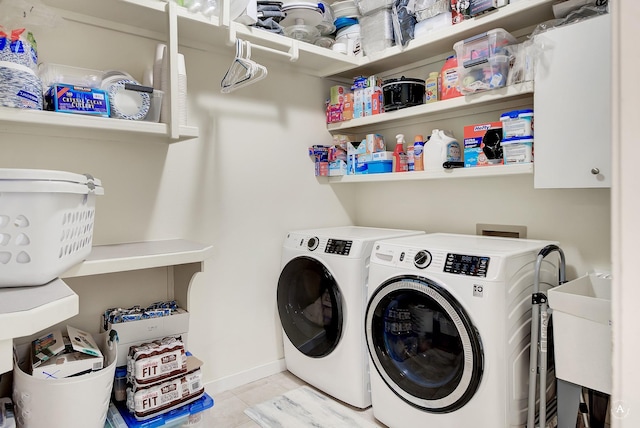 laundry area featuring a sink, baseboards, tile patterned flooring, and washer and dryer