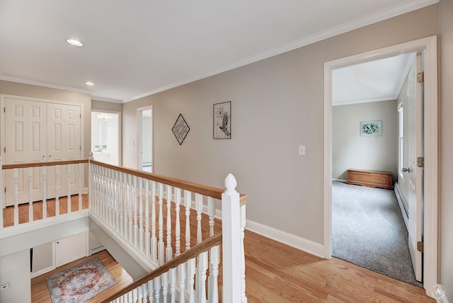 corridor with baseboards, crown molding, an upstairs landing, light wood-style floors, and recessed lighting