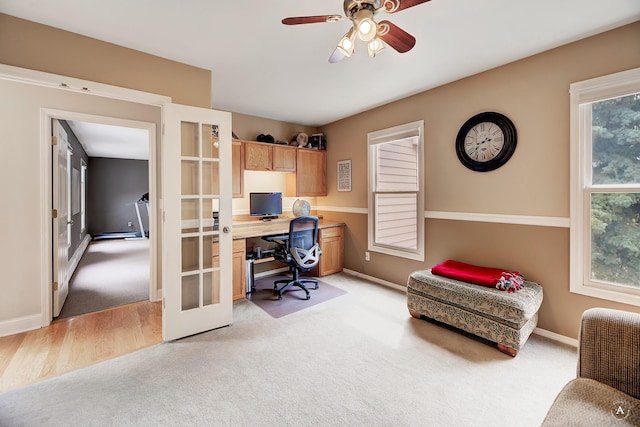 home office featuring a ceiling fan, french doors, light colored carpet, and baseboards