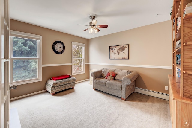 sitting room with carpet floors, a baseboard heating unit, baseboards, and a ceiling fan