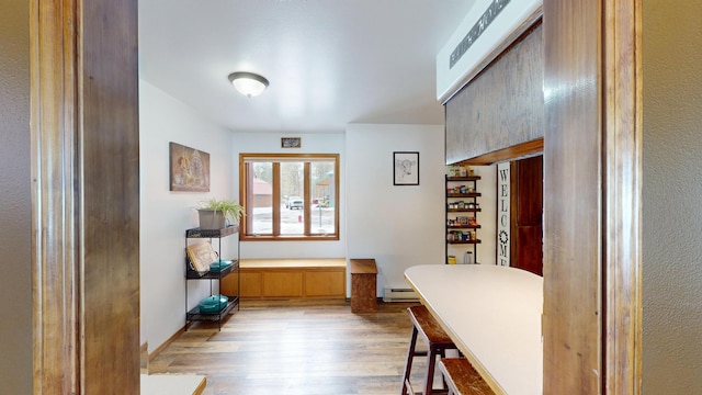 entrance foyer featuring light wood-type flooring, a baseboard radiator, and baseboards