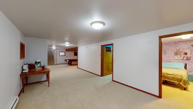 interior space with a baseboard heating unit, light colored carpet, stairway, and baseboards