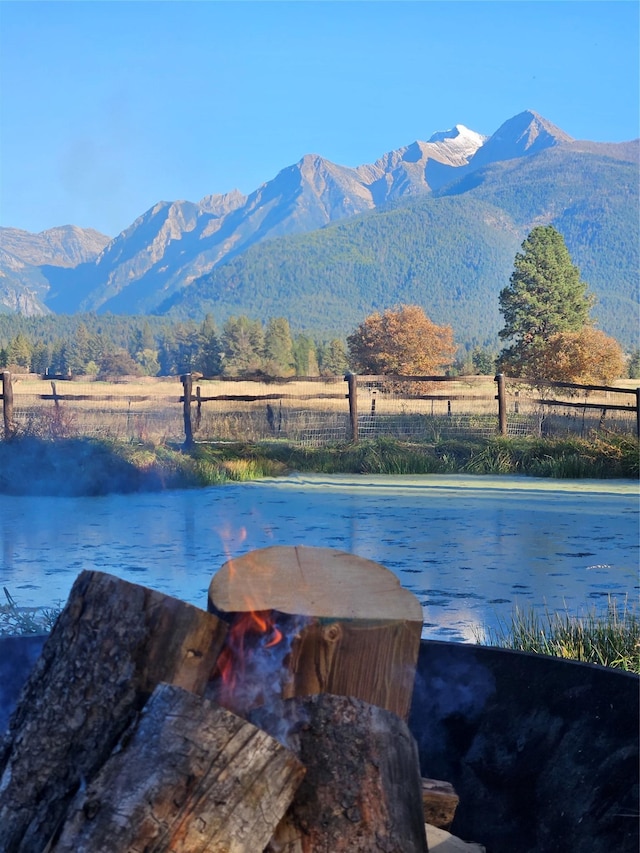 view of water feature with fence and a mountain view