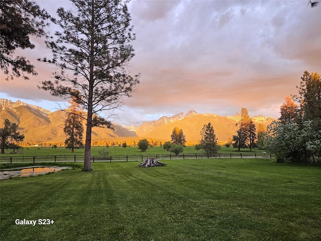 surrounding community featuring a mountain view, a lawn, and a rural view