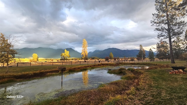 water view featuring a rural view, fence, and a mountain view