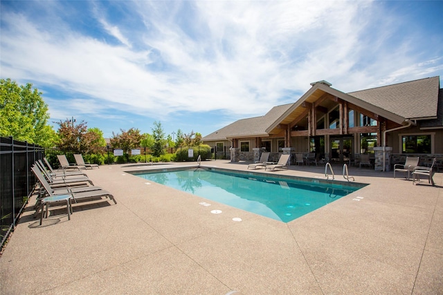 community pool featuring a patio and fence