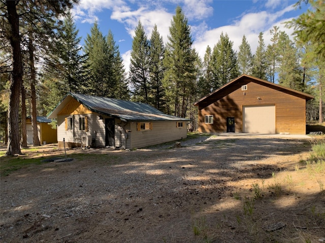 view of front of property featuring a garage, driveway, and metal roof