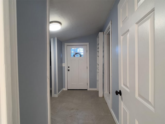 doorway featuring vaulted ceiling and baseboards