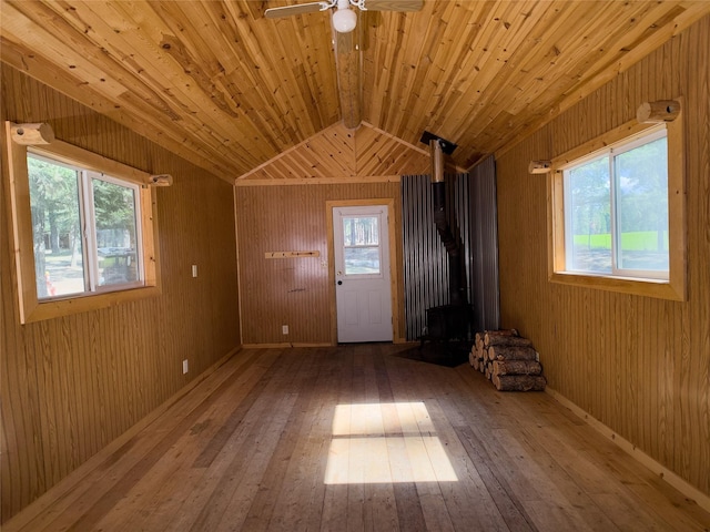 interior space with a wood stove, a healthy amount of sunlight, and hardwood / wood-style floors