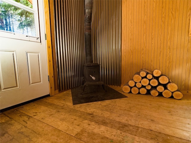 details featuring a wood stove and wood finished floors