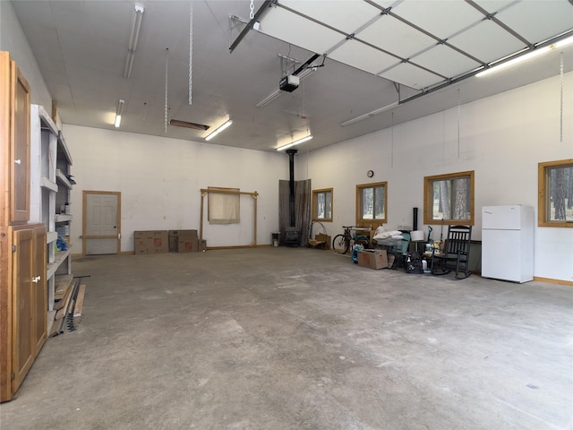 garage with freestanding refrigerator and a garage door opener