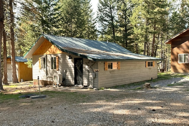 view of front of home with metal roof, driveway, and central air condition unit