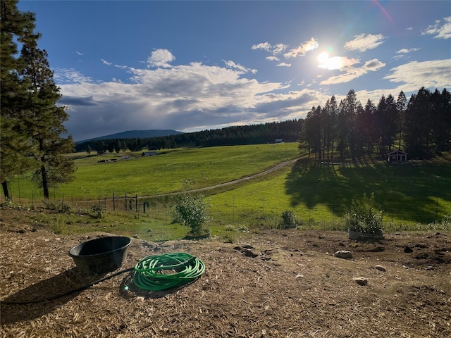 view of yard featuring fence and a rural view