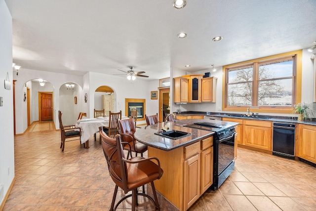 kitchen with arched walkways, glass insert cabinets, black range with electric stovetop, a kitchen bar, and a sink