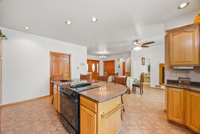 kitchen with arched walkways, open floor plan, black electric range oven, a sink, and recessed lighting