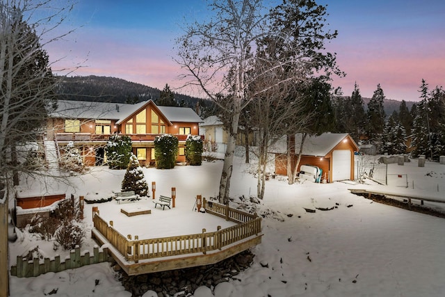 snow covered house featuring a detached garage