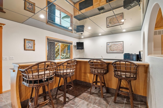 bar featuring recessed lighting, freestanding refrigerator, indoor wet bar, and tile patterned floors