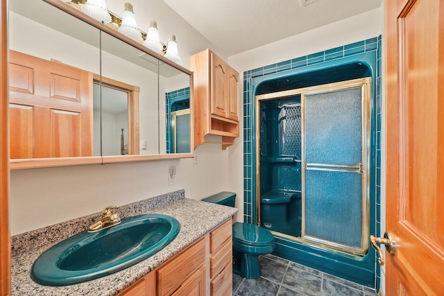 bathroom with toilet, tile patterned floors, a shower stall, and vanity