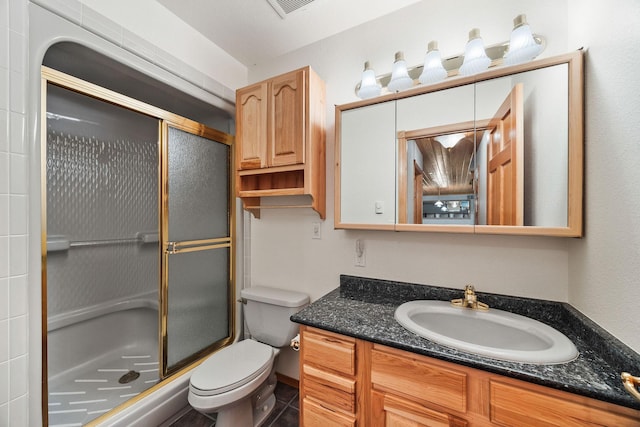 bathroom featuring toilet, visible vents, a shower stall, and vanity