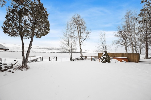 yard layered in snow featuring fence