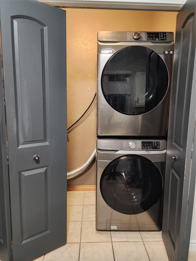 laundry area featuring laundry area, stacked washer / dryer, and tile patterned floors