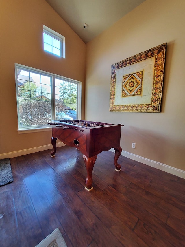 recreation room featuring lofted ceiling, baseboards, and hardwood / wood-style flooring