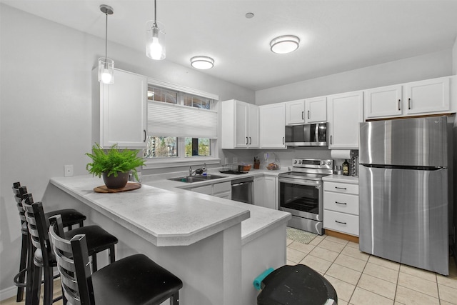 kitchen featuring stainless steel appliances, a peninsula, a sink, white cabinets, and light countertops