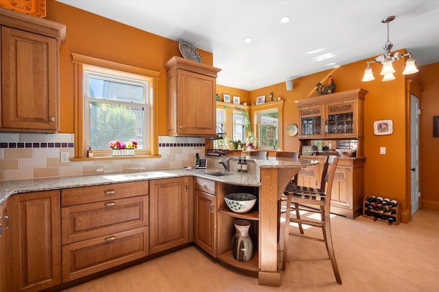 kitchen with a peninsula, tasteful backsplash, and brown cabinets