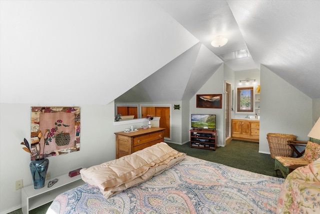 bedroom with vaulted ceiling, baseboards, dark colored carpet, and connected bathroom