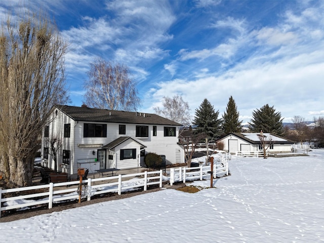 snow covered rear of property featuring a fenced front yard