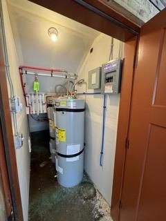 utility room featuring strapped water heater