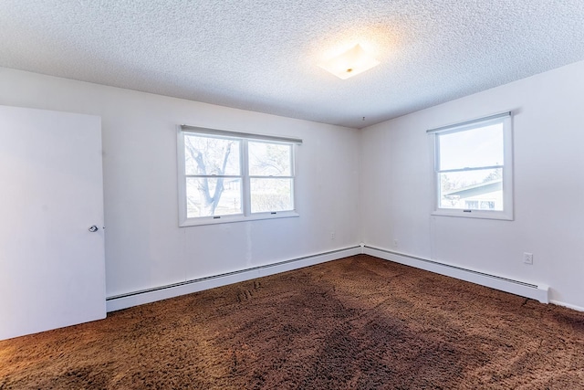 spare room with a healthy amount of sunlight, dark carpet, and a textured ceiling