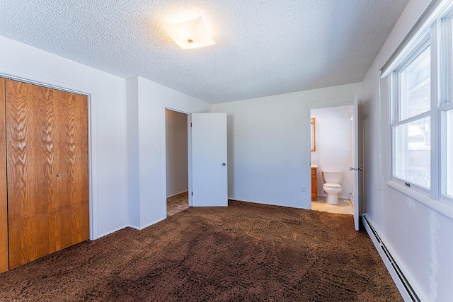 unfurnished bedroom with carpet flooring, a textured ceiling, baseboard heating, and ensuite bathroom