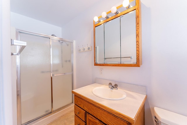 full bathroom with a stall shower, vanity, and toilet