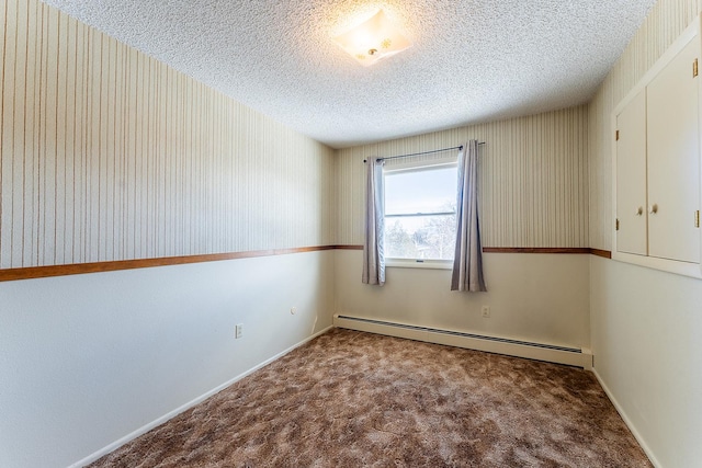 carpeted spare room with a textured ceiling, baseboard heating, and wallpapered walls