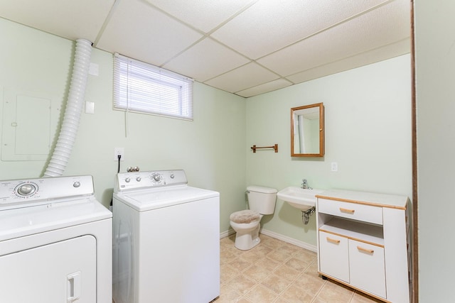 laundry area with washing machine and dryer, laundry area, a sink, baseboards, and electric panel