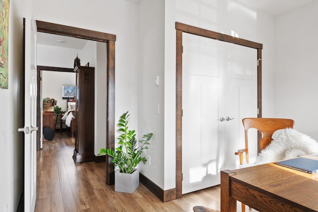 hallway featuring baseboards and wood finished floors