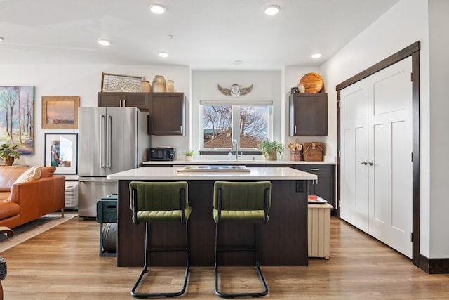 kitchen featuring light countertops, a kitchen island, light wood-style flooring, and high end refrigerator