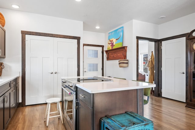 kitchen with a center island, light countertops, stainless steel range with electric cooktop, light wood-type flooring, and recessed lighting