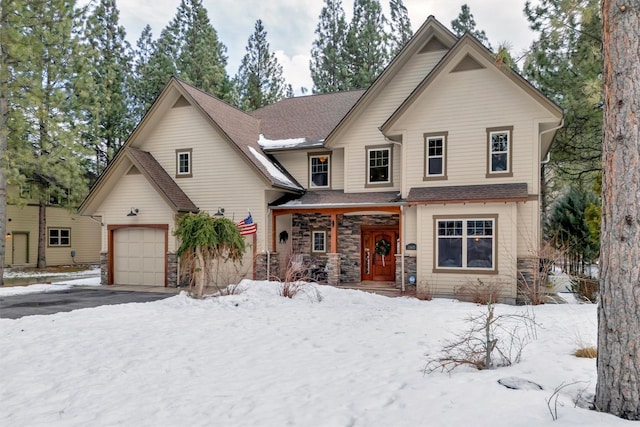 view of front facade featuring stone siding, an attached garage, and driveway