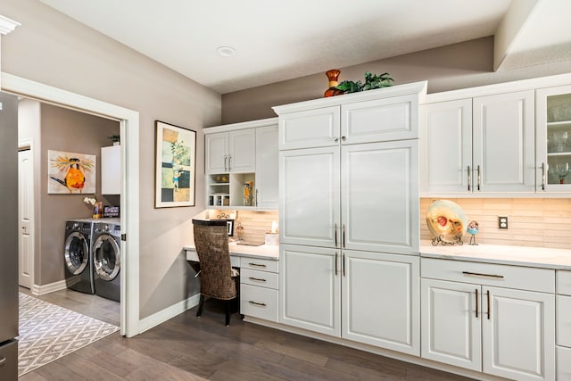 interior space with white cabinets, separate washer and dryer, dark wood finished floors, and built in study area