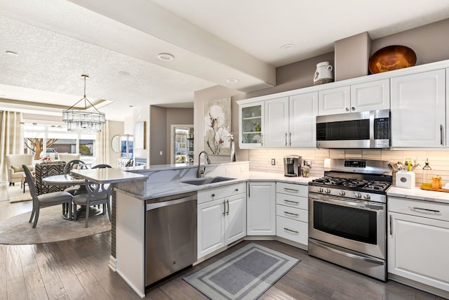 kitchen with white cabinetry, appliances with stainless steel finishes, backsplash, and a sink